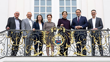 Bundesministerin Klara Geywitz (3.v.r.) zusammen mit der Bonner Oberbürgermeisterin Katja Dörner (Bildmitte) und Vertreterinnen und Vertretern der Landkreise auf der Treppe des Alten Rathauses in Bonn