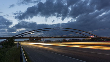 Stadtbahnbrücke Stuttgart bei der Dämmerung. Unter der Brücke sind Lichtbänder von fahrenden Fahrzeugen durch eine lange Belichtungszeit zu sehen.