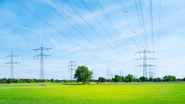 Strommasten (Überlandleitungen) auf einem freien Feld