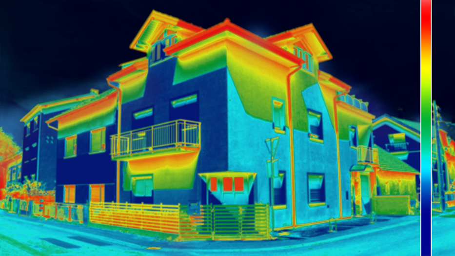 Mit einer Wärmebildkamera wird ein Wohngebäude aufgenommen. Es ist im wesentlichen in blauen (also kalten) Farben eingefärbt. Lediglich einige Segmente sind grün oder gelb (also wärmer) dargestellt. Die Dachrinnen sind rot (sehr warm) 