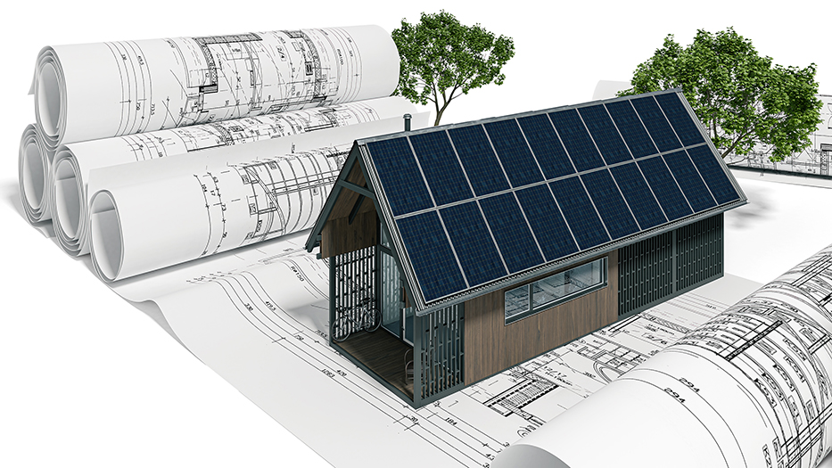 Auf einem Bauplan eines Hauses steht ein Model eines Hauses aus Holz mit Solarpaneelen auf dem Dach