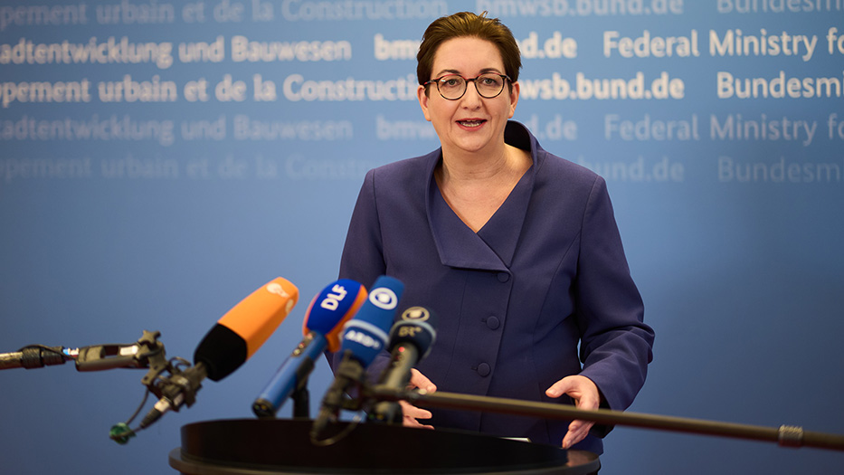 Bundesministerin Klara Geywitz am Rednerpult. Mikrofone von Medienanstatlten am unteren Bildrand