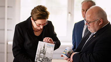 Bundesbauministerin Klara Geywitz hält ein Buch über die Stadt Lützen in den Händen.