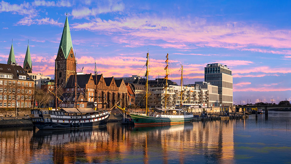 Der Hafen in Bremen von der Weser aus betrachtet. Zwei alte Segelschiffe vor der St. Martini-Kirche 