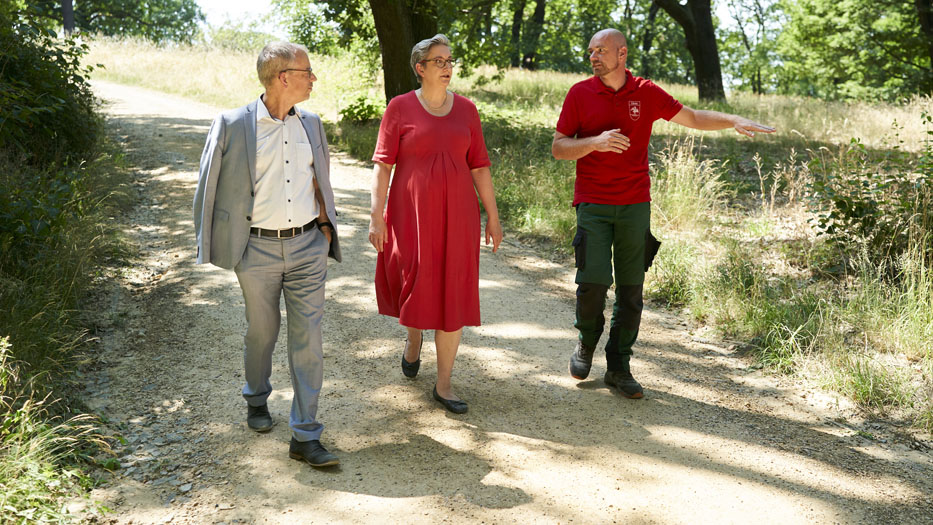 Bundesministerin Klara Geywitz bei einem Gang durch den Park Babelsberg. Ihr wird von einem Mitarbeiter der Garten-und Landschaftspflege erklärt, welche Auswirkungen das Klima auf den Park hat.