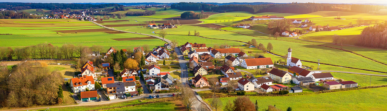 Luftbildaufnahme eines kleinen Dorfes mit landwirtschaftlicher Nutzfläche 