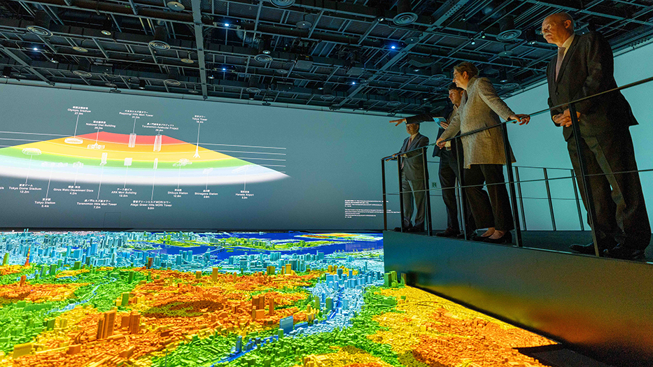 Bundesministerin Klara Geywitz besichtigt ein Modell der Region Tokio. Es können über die Lichtgestaltung z.B. Szenarien dargestellt werden.